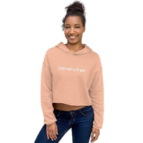 A smiling woman casually wears a peach colored cropped hoodie sweatshirt with the word Generator printed in white on the chest